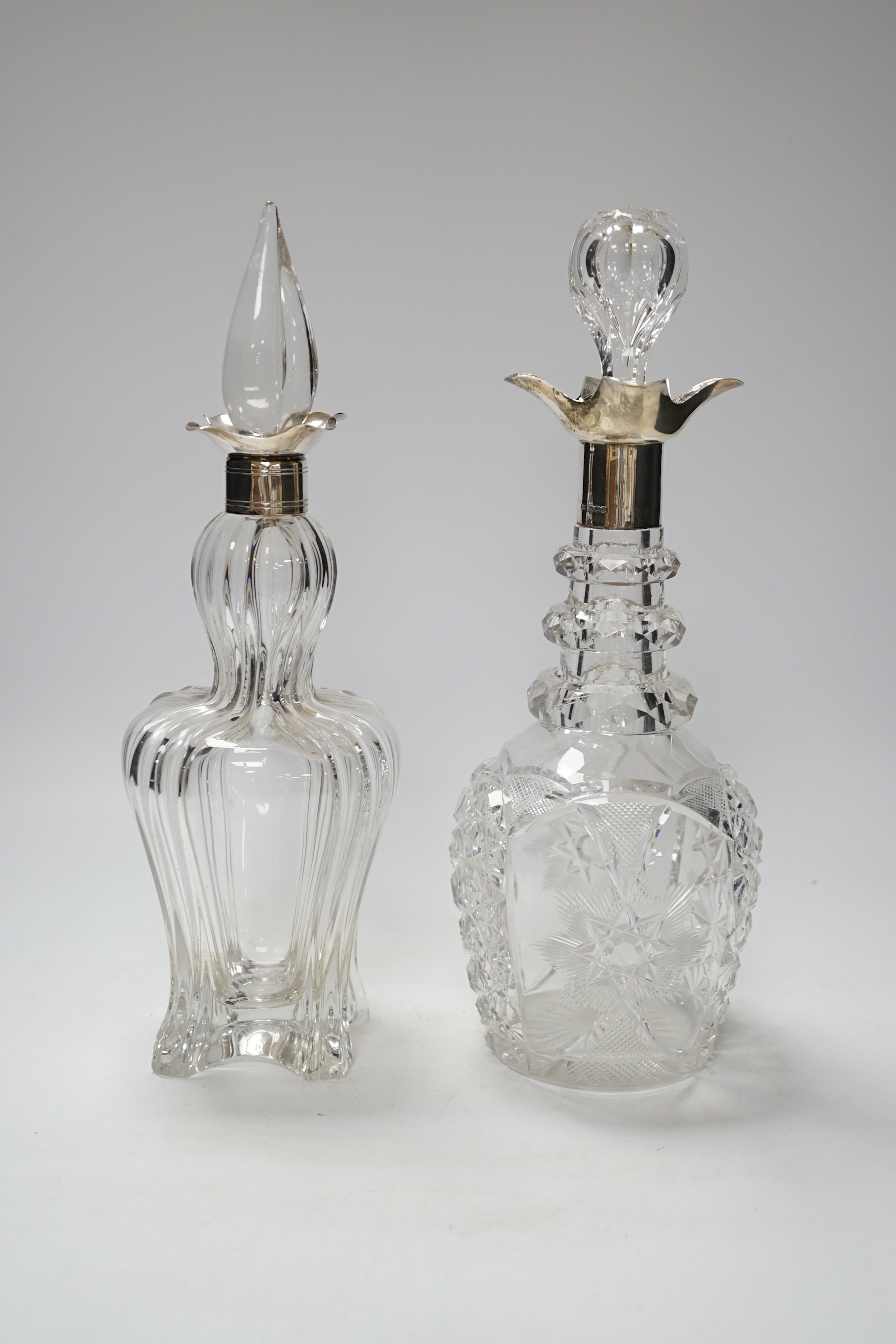 Two early 20th century silver collared cut glass decanters with stoppers, including Sheffield, 1903, tallest 32.3cm.